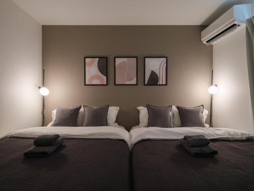 a bedroom with two beds and two lights on the wall at Pines Sakuragi-cho in Omiya