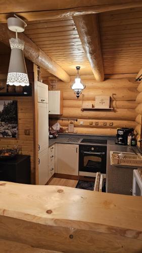 a kitchen with wooden walls and a wooden counter top at Zrubová chata Jakub in Oravská Lesná