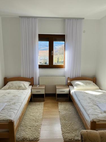 a bedroom with two beds and a window at Apartman Lucija in Rumboci