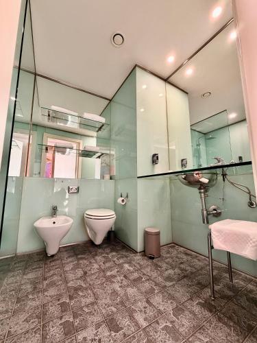 a bathroom with a toilet and a bidet and a sink at Executive Hotel in Forlì