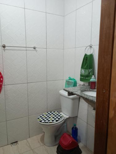a bathroom with a toilet and a sink at Casa Hum com cozinha americana in Araruama