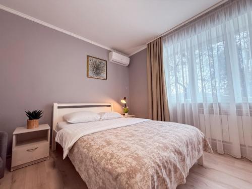 a bedroom with a bed and a large window at Kyiv Lesi 3 Studio Apartment in Kyiv