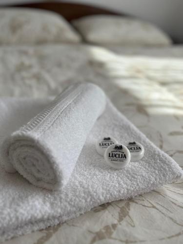 two rolls of white towels on a bed at Apartman Lucija in Rumboci