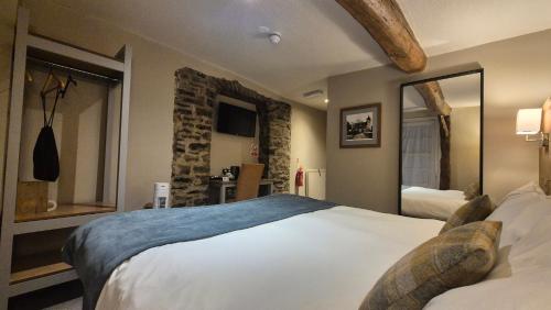 a bedroom with a large bed and a mirror at The Snooty Fox Pub in Kirkby Lonsdale