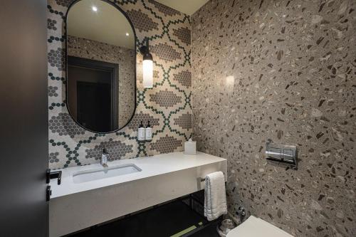 a bathroom with a sink and a mirror at Canopy By Hilton Izmir Bomonti in İzmir