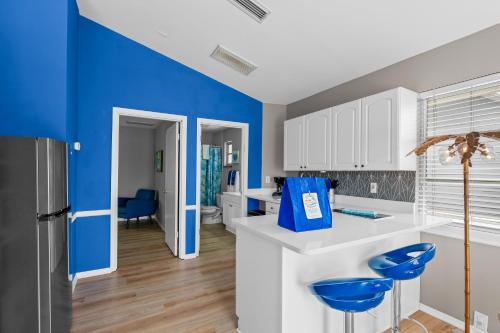a kitchen with blue walls and white cabinets at Walk to the beach - Island Villa in Siesta Key