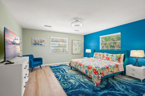 a bedroom with a bed and a blue wall at Walk to the beach - Island Villa in Siesta Key