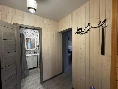 a room with wooden walls and a door and a bathroom at Bilia Tustani in Urych