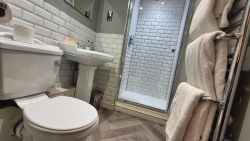 a bathroom with a toilet and a sink and a shower at The Snooty Fox Pub in Kirkby Lonsdale
