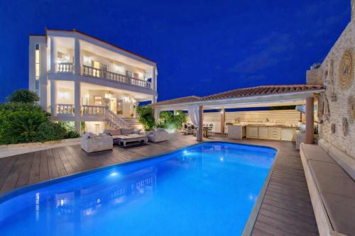 a villa with a swimming pool in front of a house at Marilyn Manor, Exclusive Hideway, By ThinkVilla in Gouves