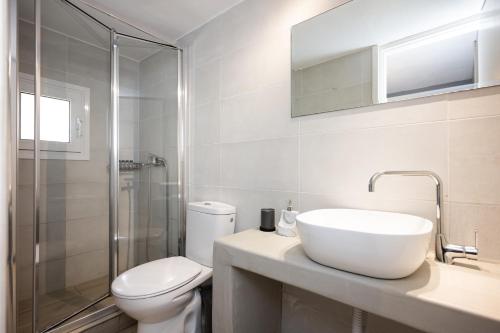 a bathroom with a sink and a toilet and a shower at The Eagle Merchia Mykonos in Merchia Beach