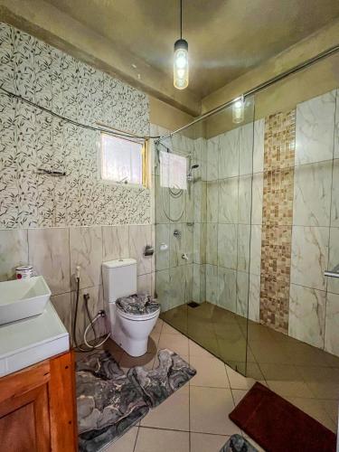 a bathroom with a toilet and a shower and a sink at Medalin Lake Gregory in Nuwara Eliya