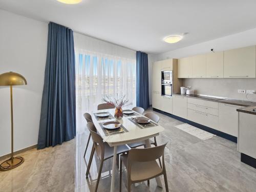 a kitchen and dining room with a table and chairs at Open Park Views 2 BR modern apartment 4 in St. Paul's Bay