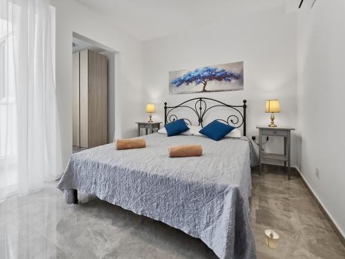 a bedroom with a large bed with blue pillows at Open Park Views 2 BR modern apartment 4 in St. Paul's Bay