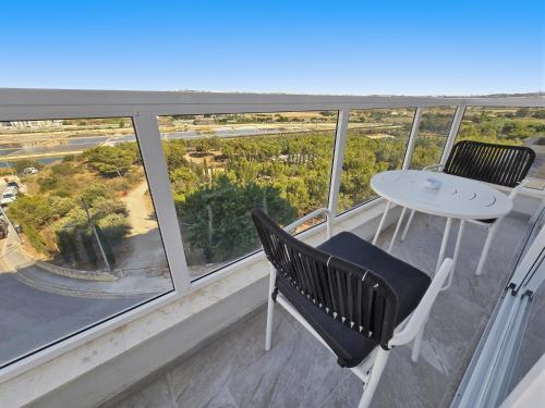 a balcony with a table and chairs and a view at Open Park Views 2 BR modern apartment 4 in St. Paul's Bay