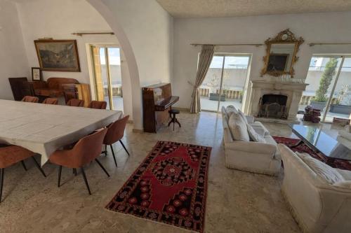 a living room with a table and a fireplace at Stunning Villa with Pool, Table tennis, Table soccer and a Pool table in Naxxar