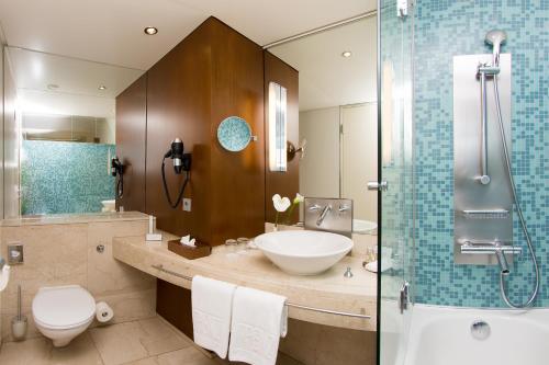 ein Bad mit einem Waschbecken, einem WC und einer Dusche in der Unterkunft The PENZ Hotel in Innsbruck