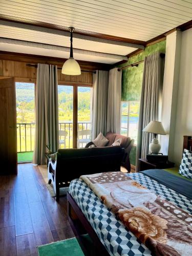 a bedroom with a bed and a couch and windows at Medalin Lake Gregory in Nuwara Eliya