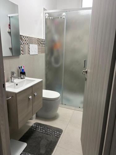 a bathroom with a shower and a toilet and a sink at Home Sicilia in Carini