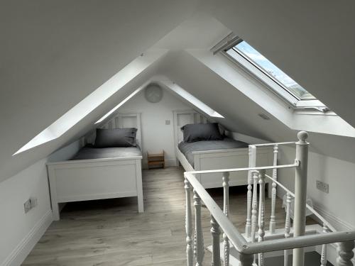 a attic room with two beds and a skylight at Mid- Village Croft in Cairndow