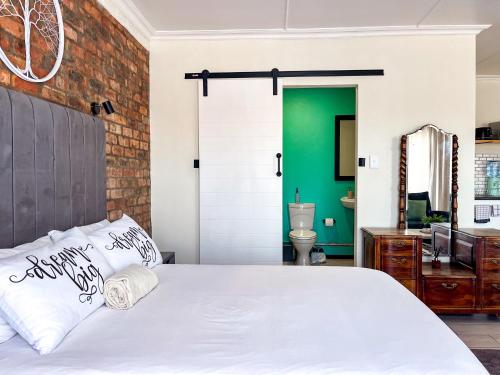 a bedroom with a white bed and a green wall at Cozy Cottage in Langebaan