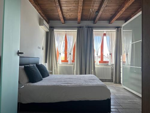 a bedroom with a bed in a room with windows at Ancient village in Trieste