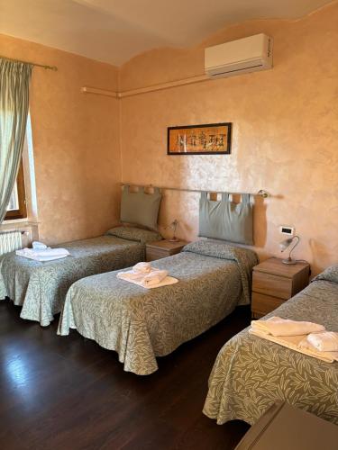 a hotel room with three beds in a room at Albergo Vecchio Pavone in Borgaro Torinese