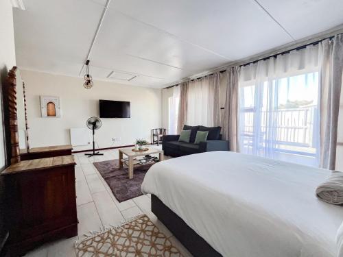 a bedroom with a bed and a living room at Cozy Cottage in Langebaan