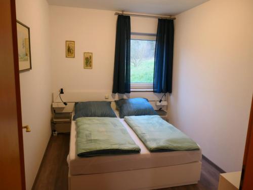 a small bedroom with a bed and a window at Ferienwohnung Doris in Schmalkalden