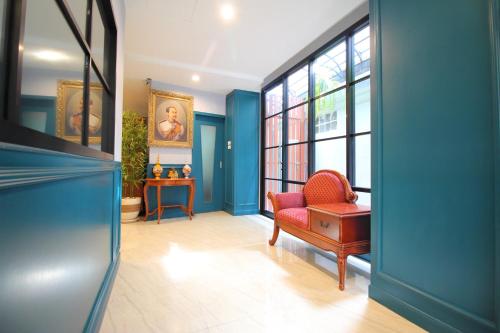 a living room with blue walls and a red chair at Super OYO 484 Pannee Residence Khaosan Sha Plus in Bangkok
