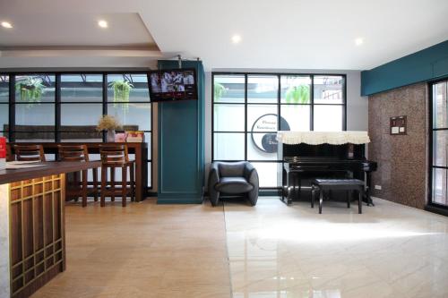 a living room with a piano and a bar at Super OYO 484 Pannee Residence Khaosan Sha Plus in Bangkok