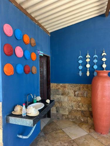 a bathroom with a blue wall with a sink and a vase at Juscelino Pousada lazer in Tibau