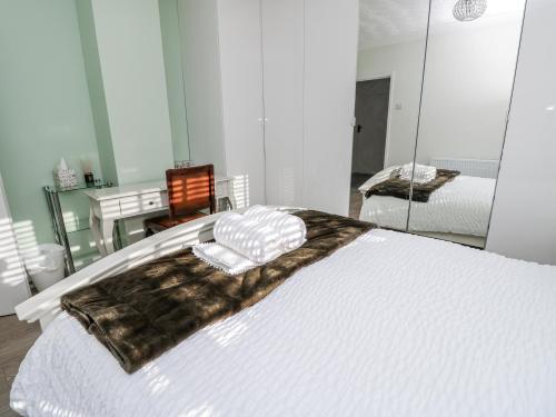 a bedroom with a large white bed with a mirror at Red Brick Haven in East Cowes