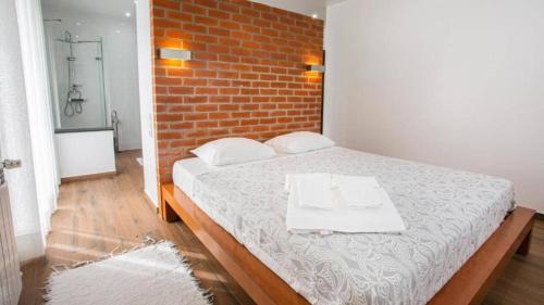 a bedroom with a bed and a brick wall at Quinta do Vale Vendeiro in Figueira da Foz