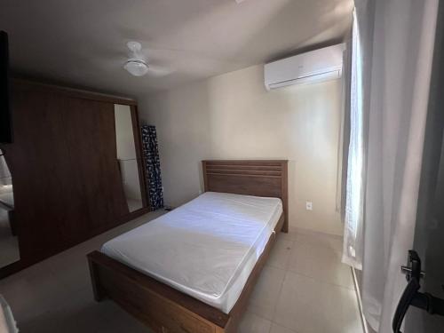 a small bedroom with a bed and a window at Chalé com Piscina e Churrasqueira Privativos in Búzios