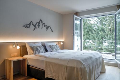 a bedroom with a bed and a large window at Studio 54 Davos in Davos