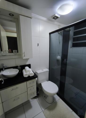 a bathroom with a toilet and a sink and a shower at Apto 2Q Centro Wifi Shopping Garage in Taubaté