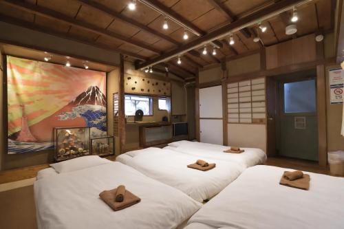 a room with four beds with brown crosses on them at Large Private House for 18 Tokyo Tower JR Hamamatsucho 8min HOTEL Musashi Tokyo Shiba in Tokyo