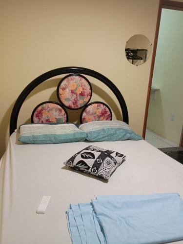 a bed with three plates on the head board at Casa três com cozinha americana in Araruama
