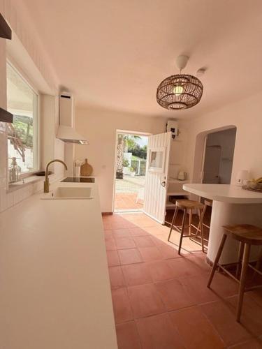 a kitchen with a sink and a table with chairs at Casa Branca in Sesimbra