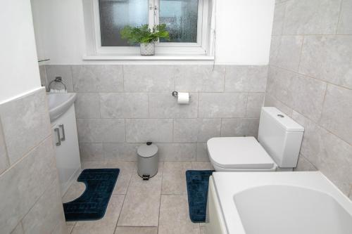 a bathroom with a toilet and a sink and a window at Contractor Accommodation, Free Large Car Park, Sleeps 7 in Kent