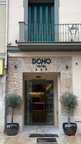 a dolo hotel entrance with two plants in front of a building at Hotel Doho in Málaga