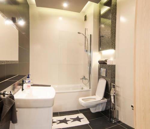 W łazience znajduje się toaleta, umywalka i prysznic. w obiekcie Apartamenty Mariańska 103 w mieście Racibórz
