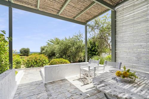 an outdoor patio with a table and chairs at Niriides Beachfront Resort in Gythio