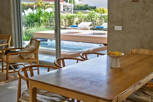 a dining room table with chairs and a pool at Jadrija Luxury Vacations Apt1 in Šibenik