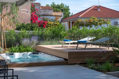 a hot tub on a deck with a table and a chair at Jadrija Luxury Vacations Apt1 in Šibenik