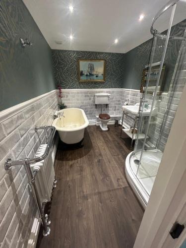 a bathroom with a tub and a sink and a toilet at Ashleigh Buxton in Buxton
