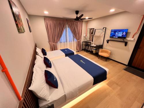a hotel room with a bed and a television at AURELIA Stay in Brinchang