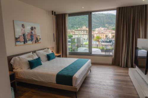 a hotel room with a bed and a large window at LKL Lakeside Lodging in Paratico