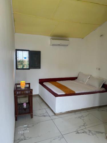a white room with a bed and a table at O'Sole Mio Assinie - La résidence in Assinie